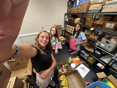 A group of teenagers girls in a room with boxes